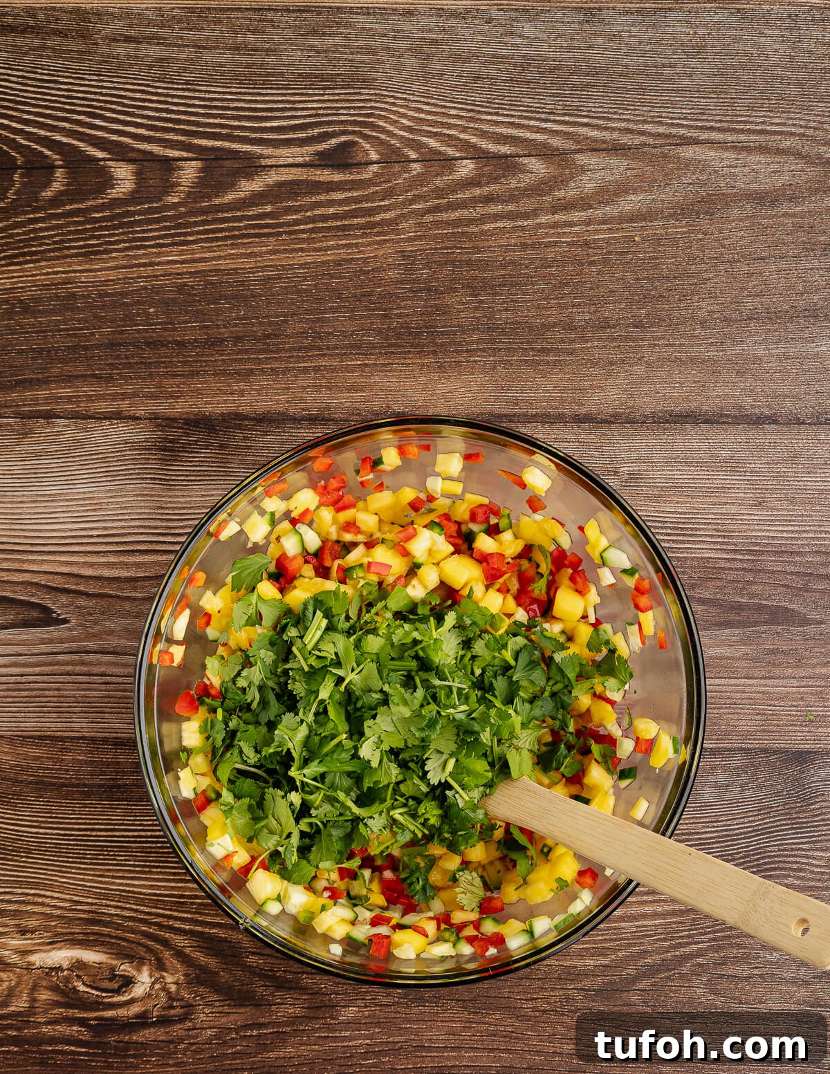 Tangy Pineapple Mango Salsa Recipe for Grilled Fish & Tacos 11 diced pineapple, cucumber, red bell pepper, and mango with cilantro on top.