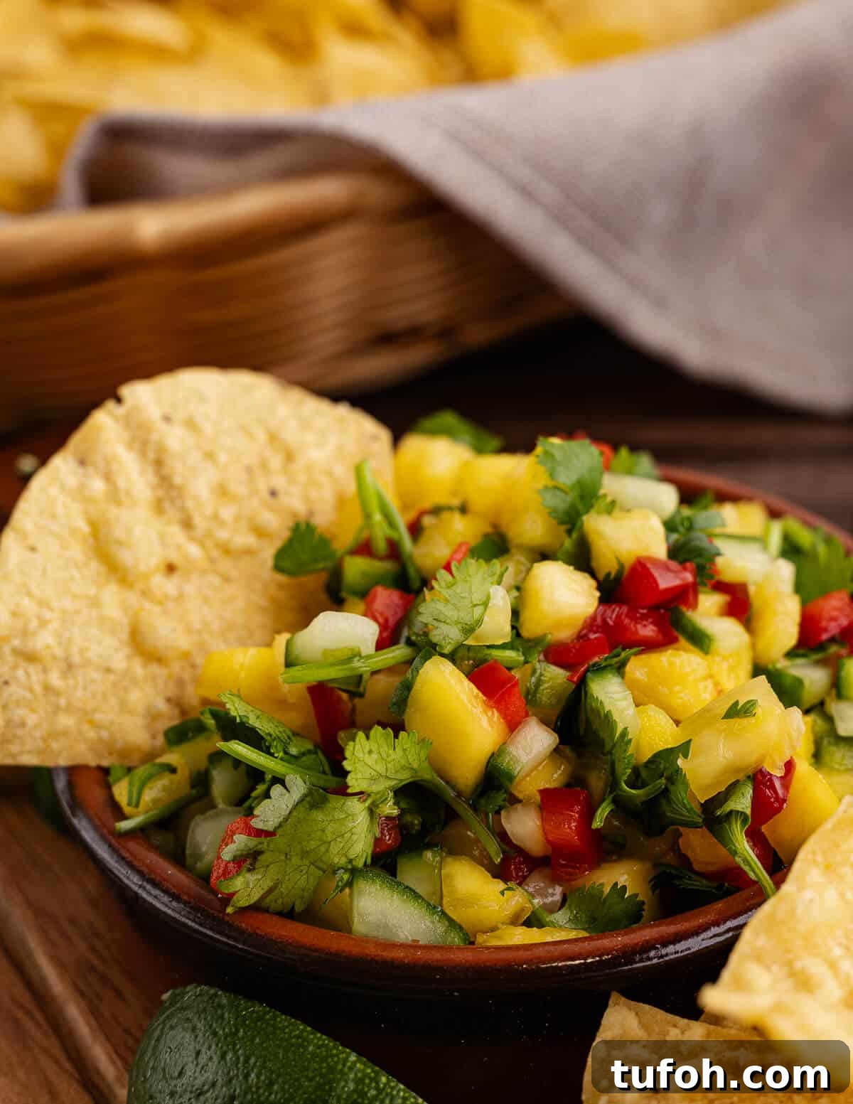 Tangy Pineapple Mango Salsa Recipe for Grilled Fish & Tacos 14 a bowl of salsa with a chip in it.