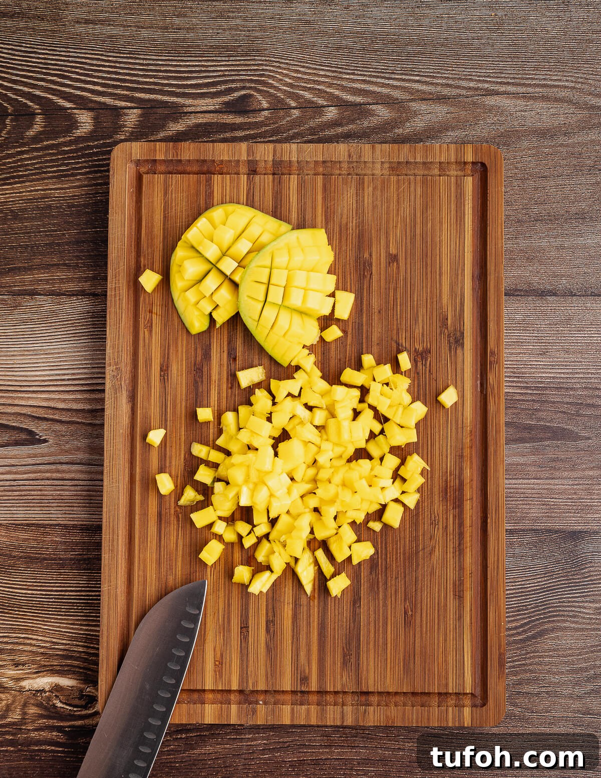 Tangy Pineapple Mango Salsa Recipe for Grilled Fish & Tacos 8 small diced mango on a cutting board.