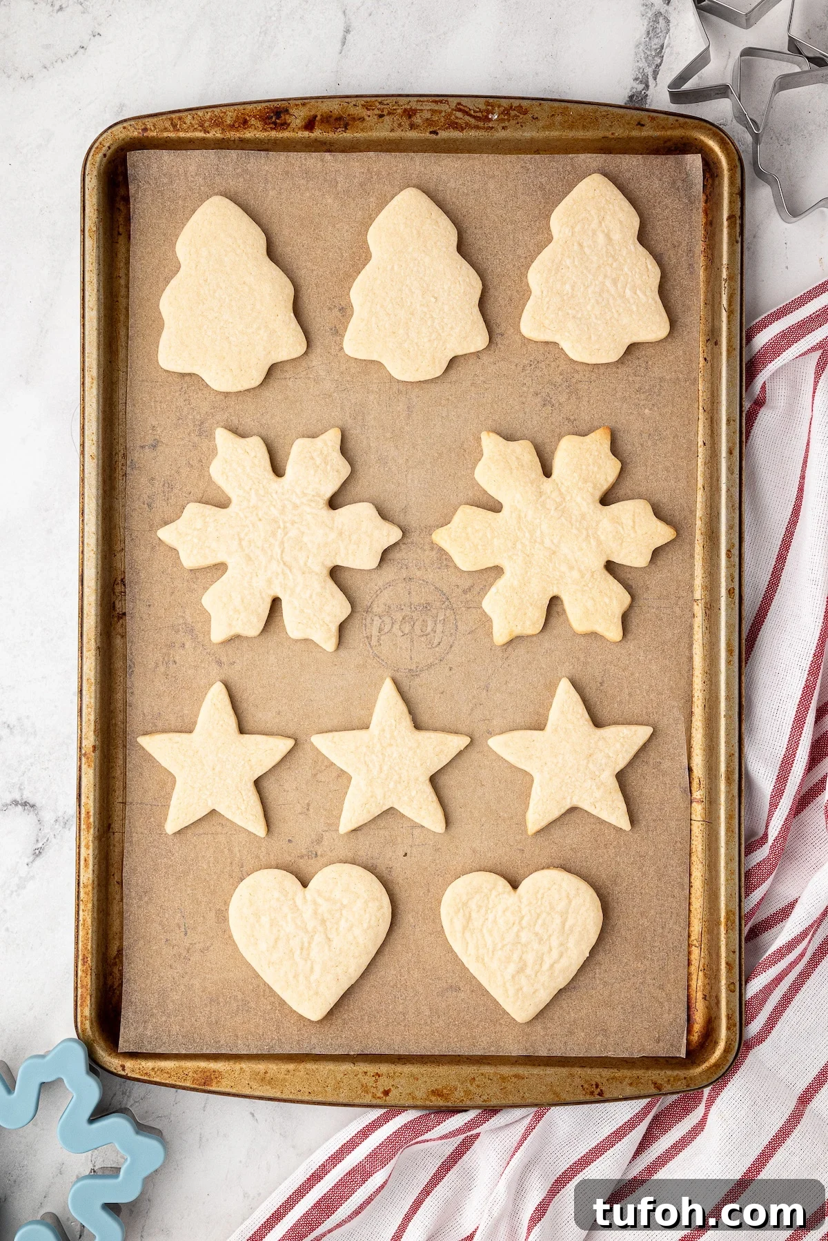 Soft Cut-Out Sugar Cookies Recipe for Tender, Perfect Shapes 8 Baking sheet of baked roll out Christmas cookies cooling.