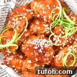 Up close view of korean fried chicken in parchment-lined bowl.