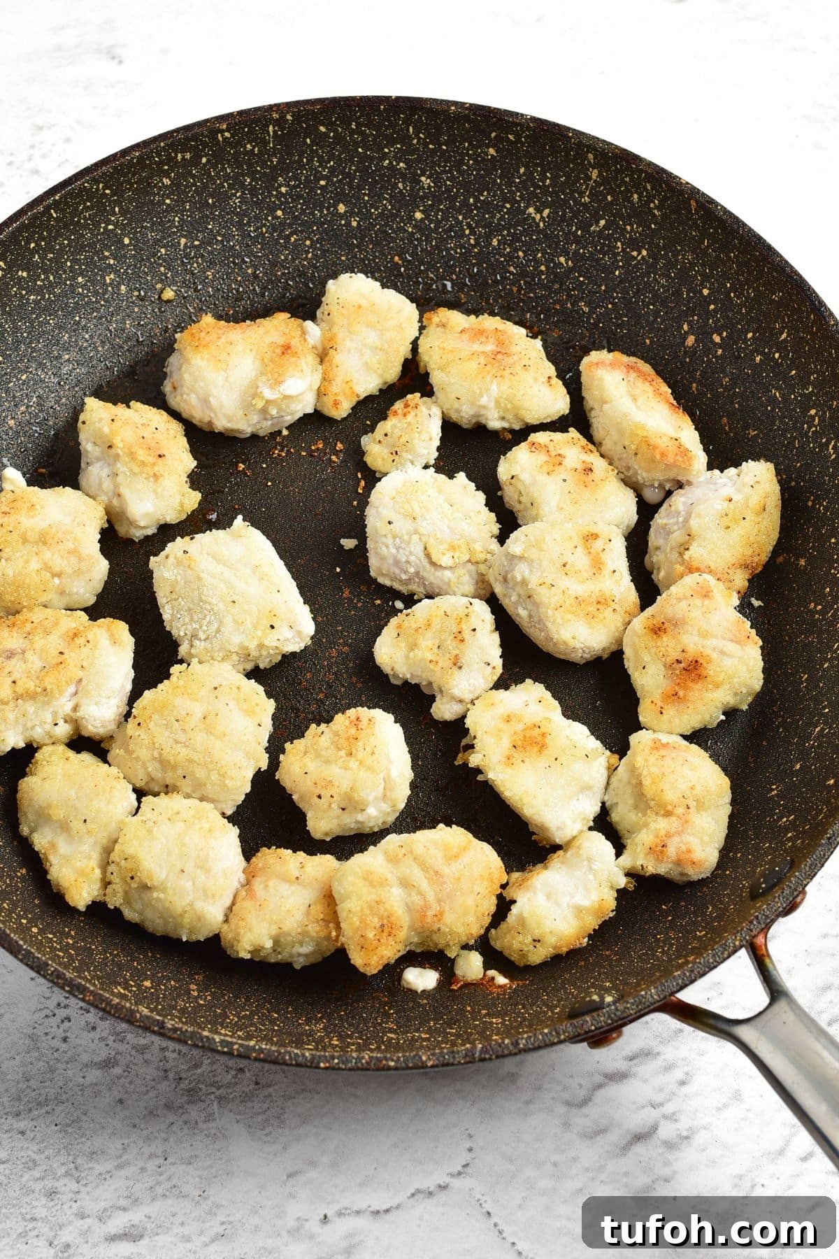 Gluten Dairy-Free Korean-Style Chicken Pan-frying coated chicken pieces in skillet