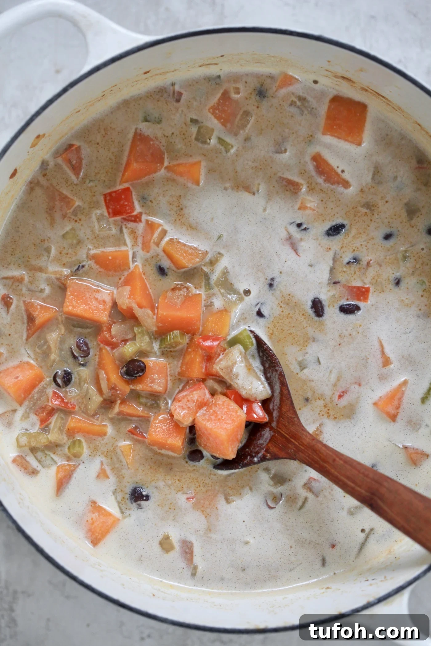 Creamy Dairy-Free Sweet Potato and Black Bean Soup Recipe 5 creamy soup with sweet potatoes and wooden spoon
