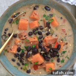 bowl of black bean soup with sweet potatoes and spoon