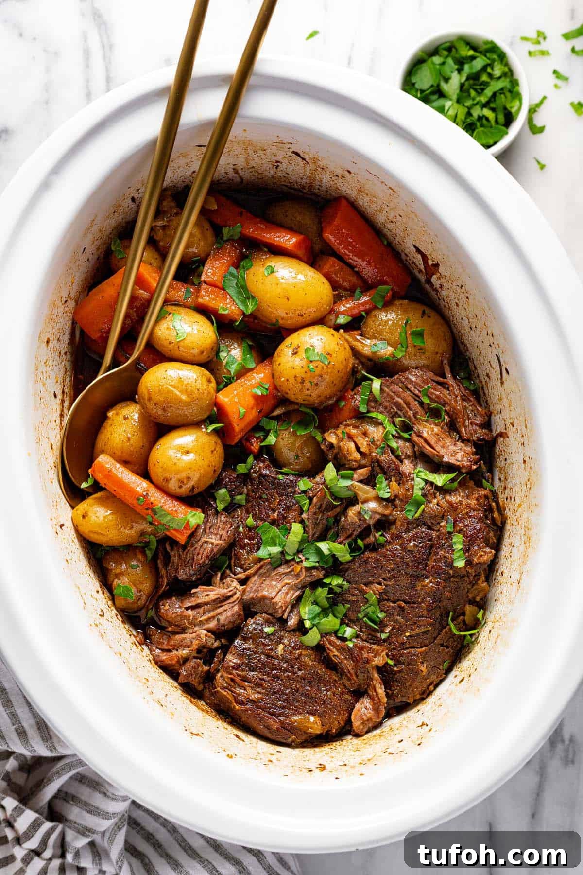 Slow-Cooker Pot Roast with Rich Homemade Gravy 7 Large crock pot insert filled with crock pot pot roast garnished with fresh parsley.