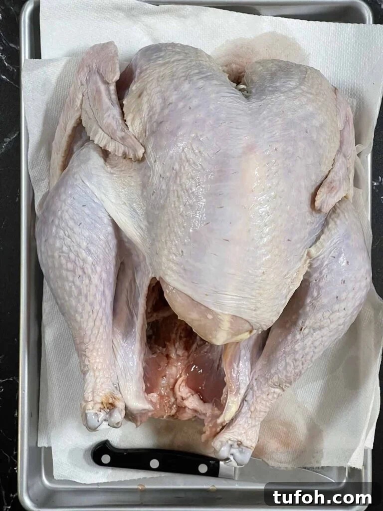 Perfect Whole Smoked Turkey: Year-Round Smoking Guide 5 A raw turkey on a baking sheet.