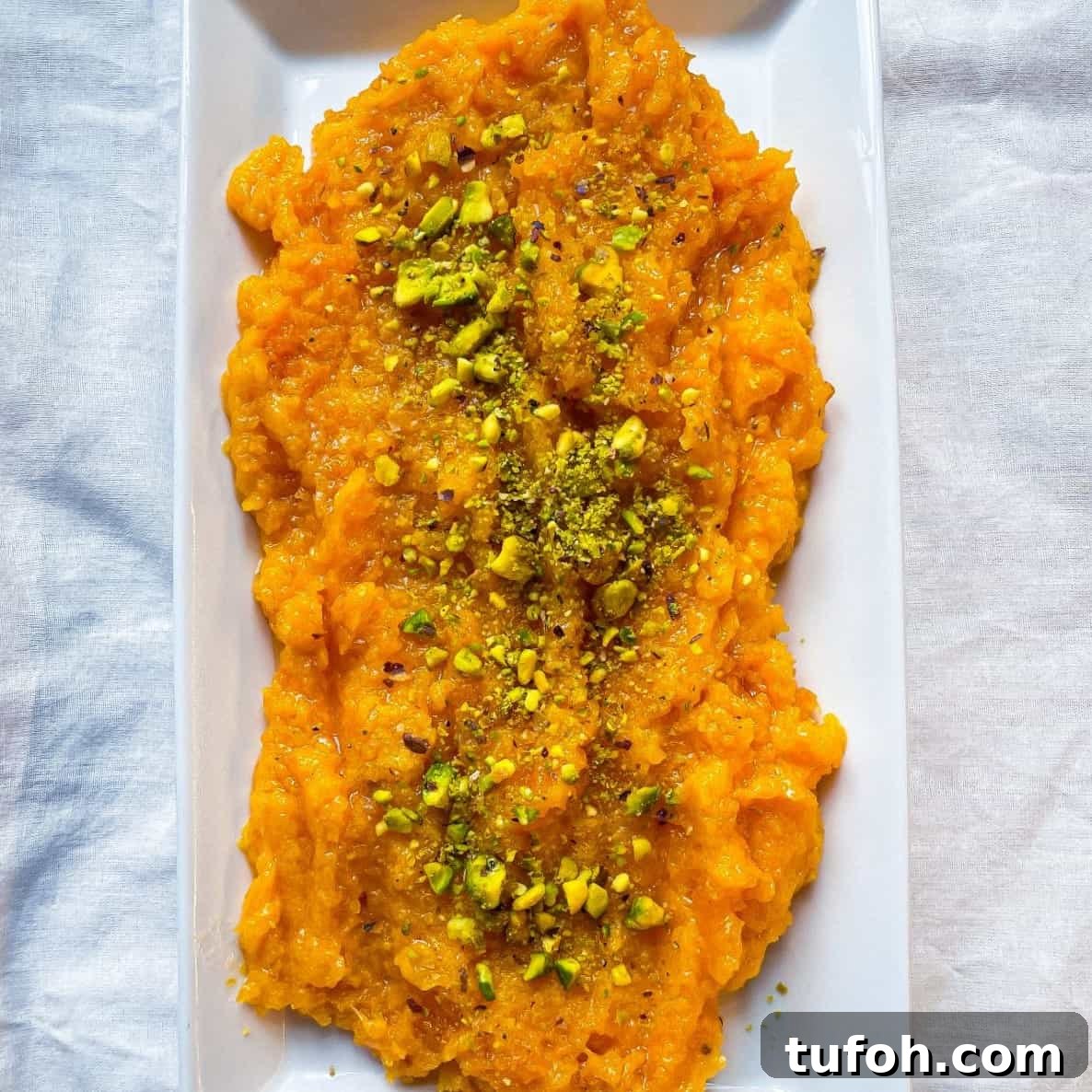 A plate of pumpkin halwa garnished with chopped pistachio