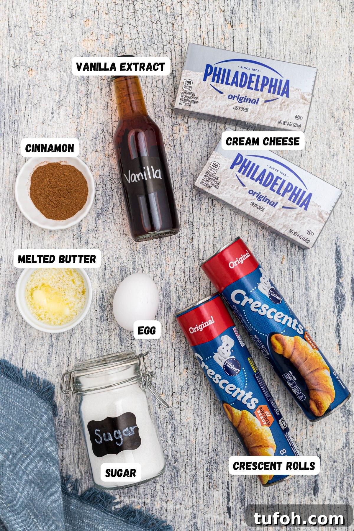 Churro Cheesecake Recipe: Cinnamon-Sugar Cheesecake Bars 3 Ingredients measured into small bowls on a wooden tabletop.