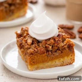 Plated pumpkin pecan pie bar with a dollop of whipped cream on top.
