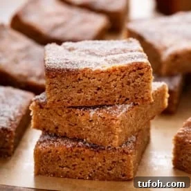 Stacked apple cider blondies on parchment.