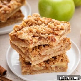 Bite from an apple crisp bar on the top of a stack of bars.