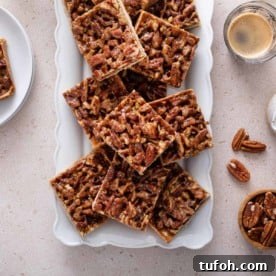 Pecan bars arranged on a white platter.