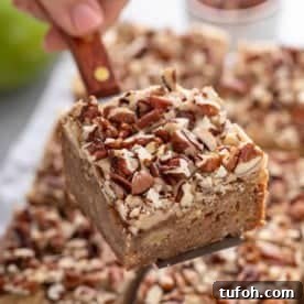 Cake server holding a caramel apple blondie up to the camera.