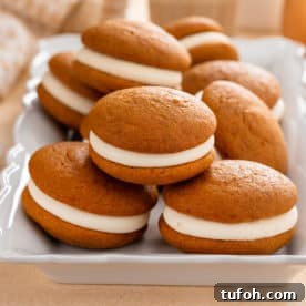 Pumpkin whoopie pies stacked on a platter.