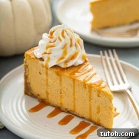 Slice of pumpkin cheesecake next to a fork on a plate