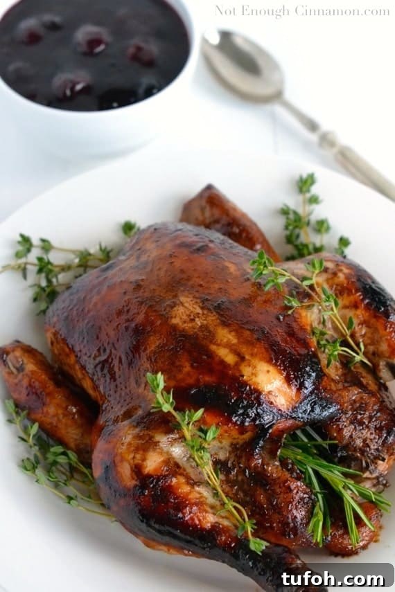 Balsamic Roasted Chicken with Cherry Pan Sauce 2 Balsamic Roasted Chicken served on a white platter with a small side dish of Easy Cherry Sauce in the background