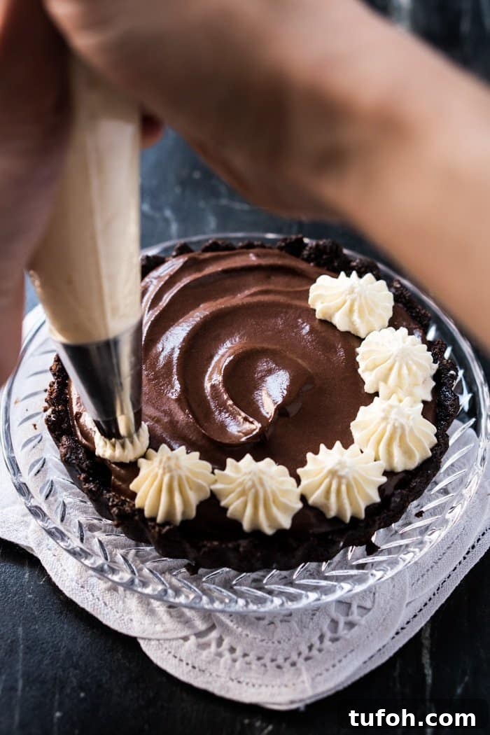 Single-Serve Chocolate French Silk Pie (Gluten-Free, Keto & Paleo) 4 Piping whipped cream onto a keto French silk pie