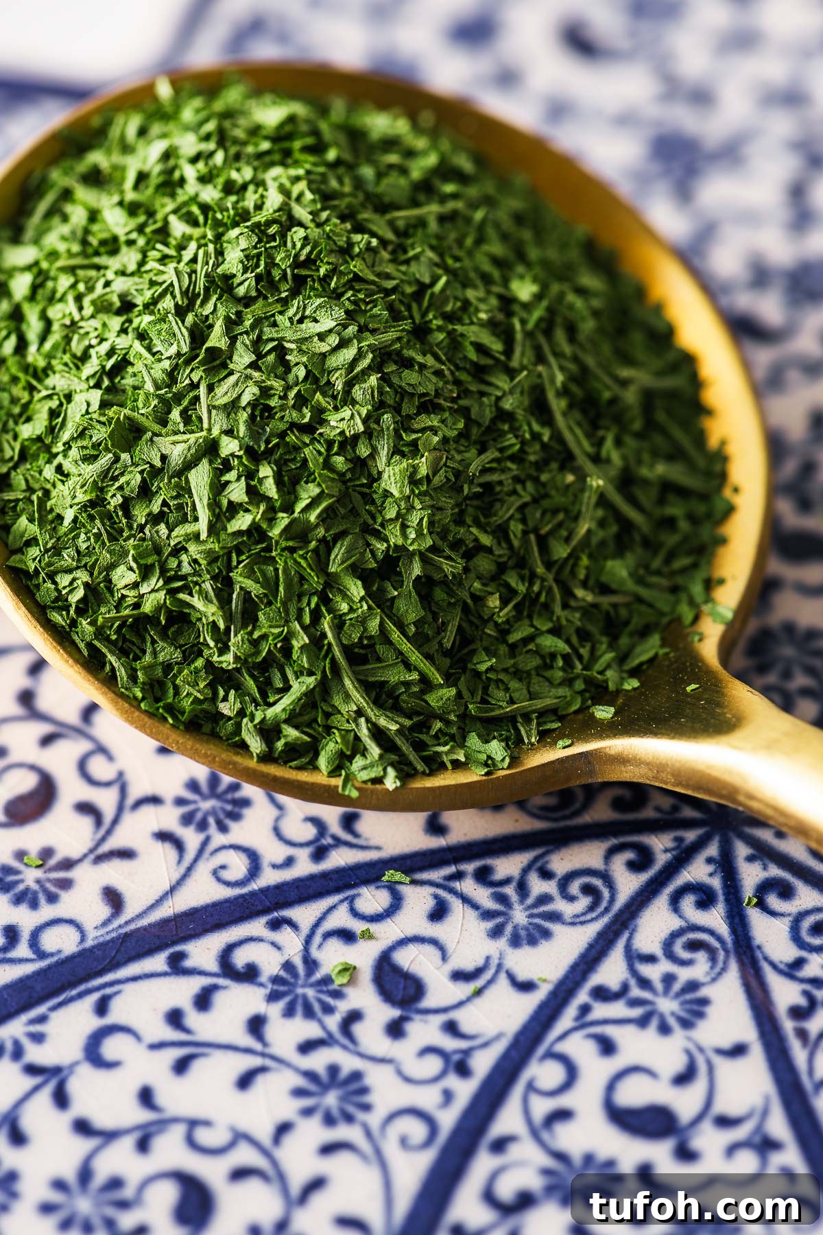 Oven-Dried Parsley: A Simple Guide for Long-Lasting Flavor 3 A close-up of a tablespoon of dried parsley on a patterned background.