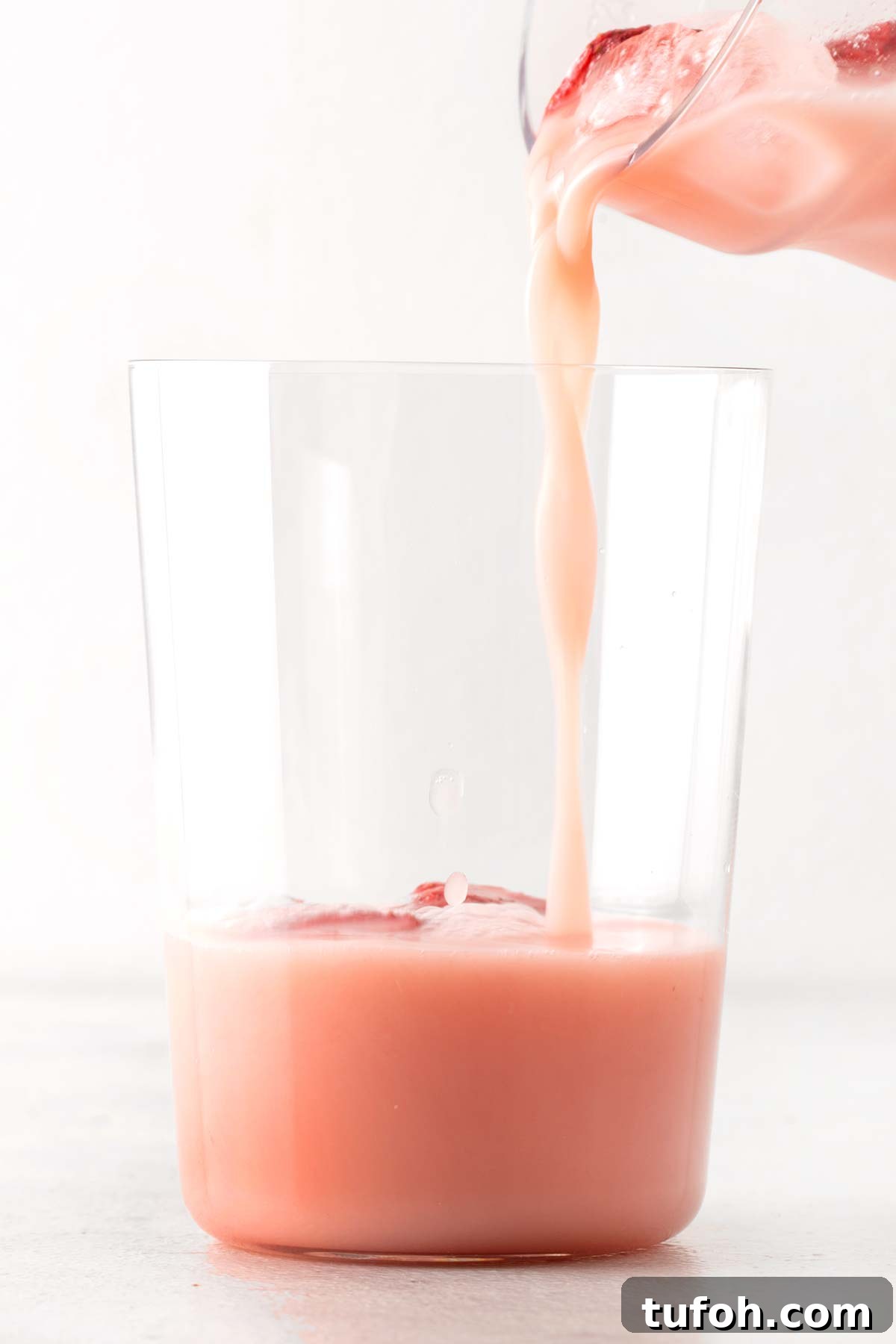 Pouring homemade Pink Drink into a cup.