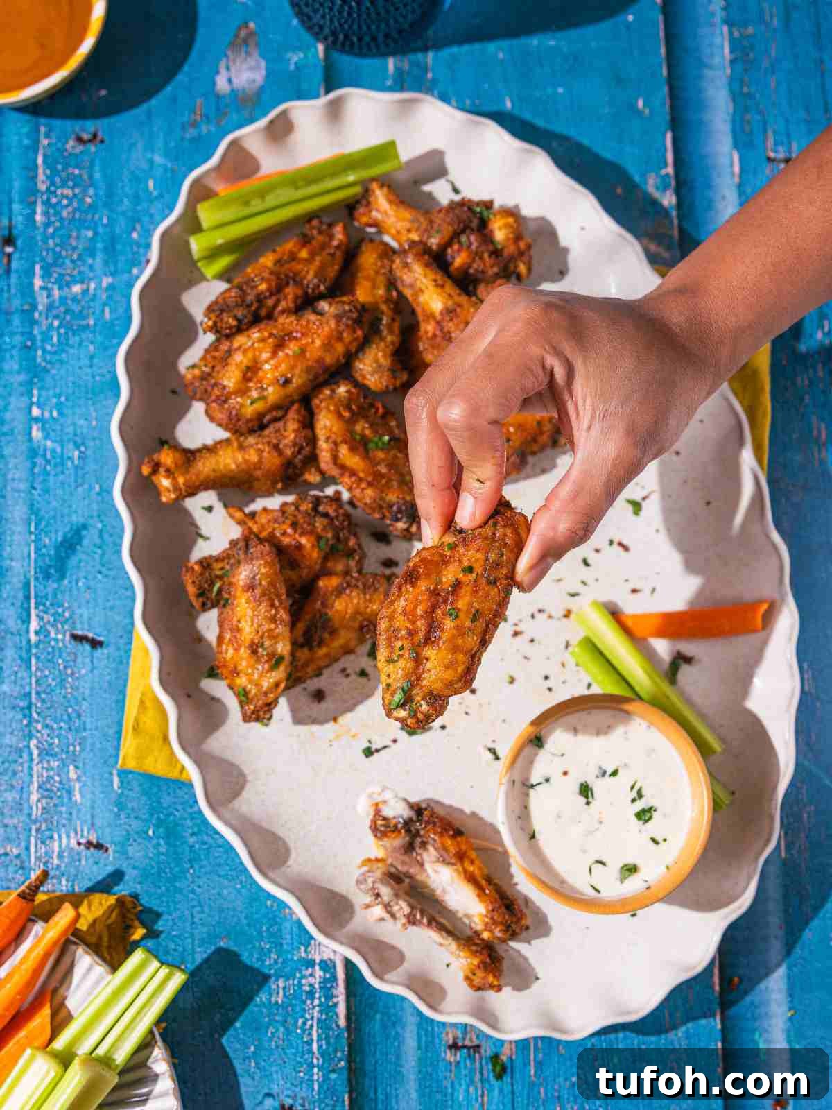 Air Fryer Frozen Chicken Wings (Cook Without Thawing) 4 A close up of crisp wings garnished with chopped parsley.