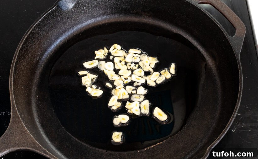 Sliced garlic and peanut oil in a skillet.