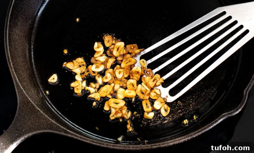 Cooked sliced garlic in a skillet.