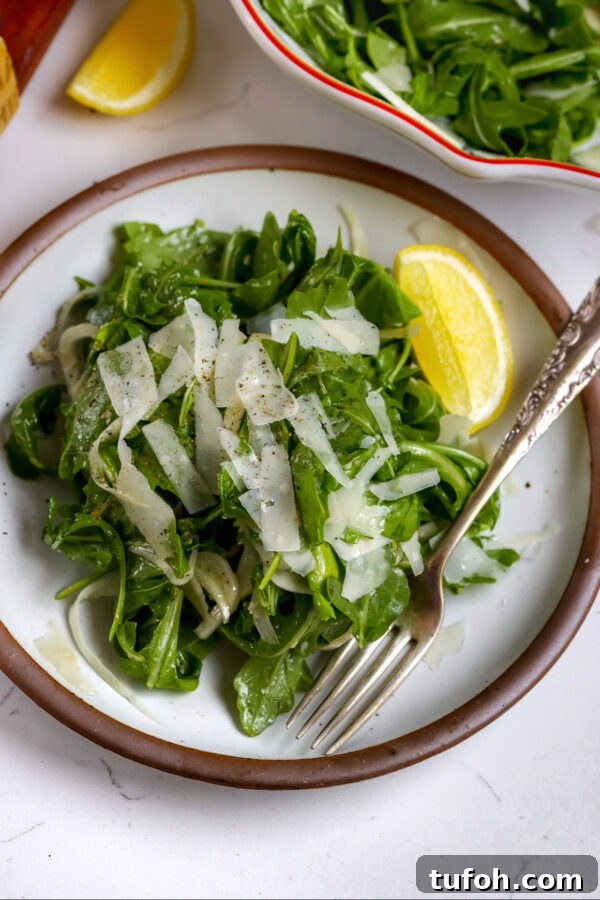 Classic French Carrot Salad with Lemon and Herbs 5 An arugula fennel salad with a delicious honey dijon dressing with a lemon on the side and fork in the plate.