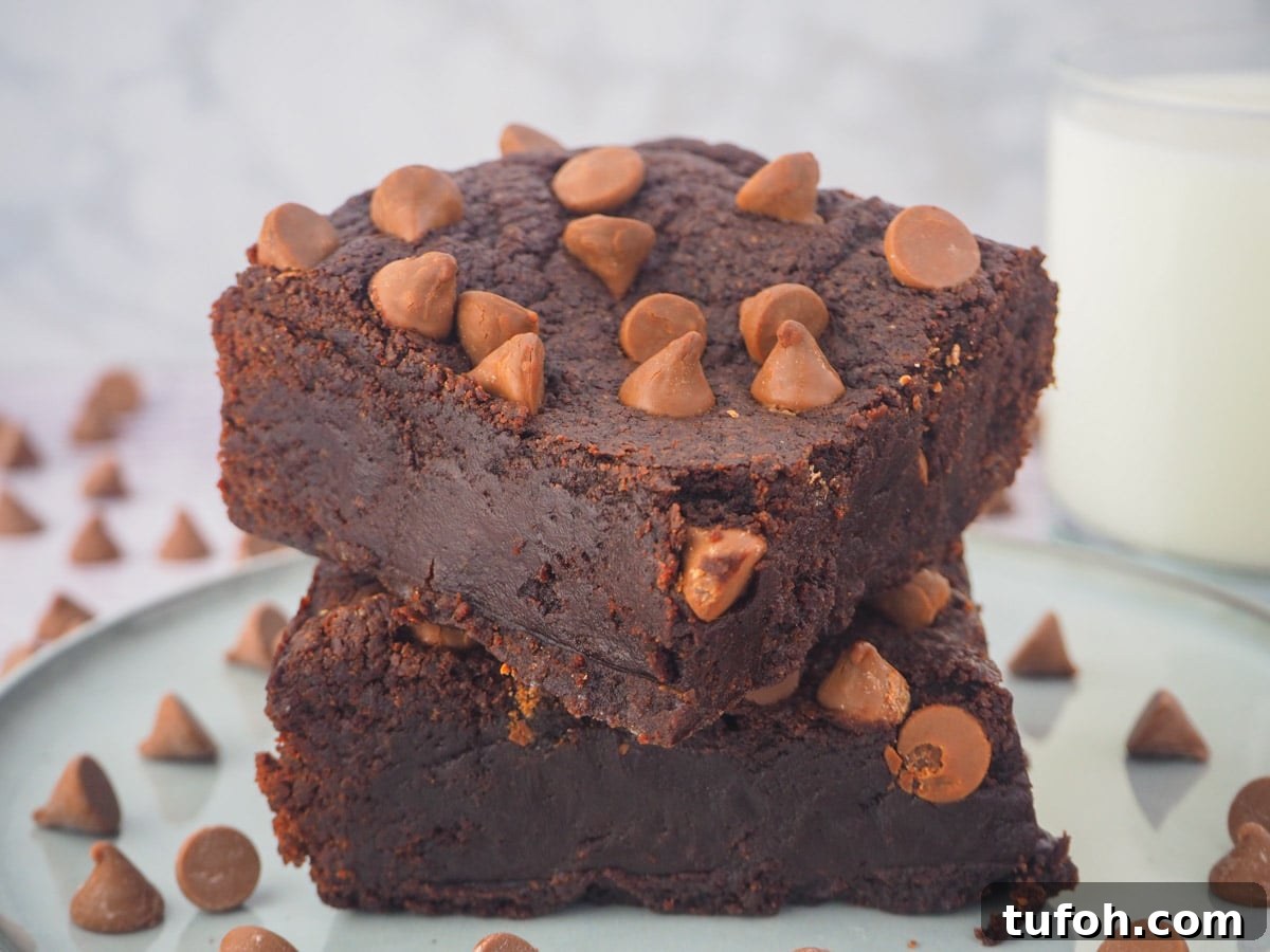 Decadent Egg-Free Brownies: Fudgy, Moist Recipe 14 Stack of eggless brownies on a plate with a glass of milk in the background.