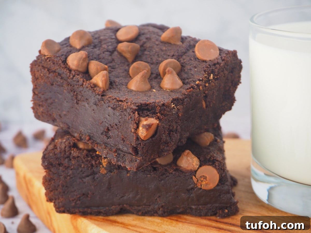 Decadent Egg-Free Brownies: Fudgy, Moist Recipe 4 Stack of eggless brownies on a board with a glass of milk.