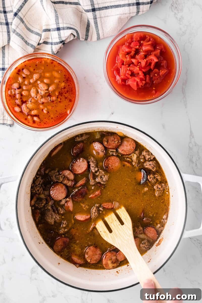 Hearty Cowboy Stew Recipe: Classic Beef and Bean Dinner 7 adding the broth to the pot with the beans and tomatoes on the side.