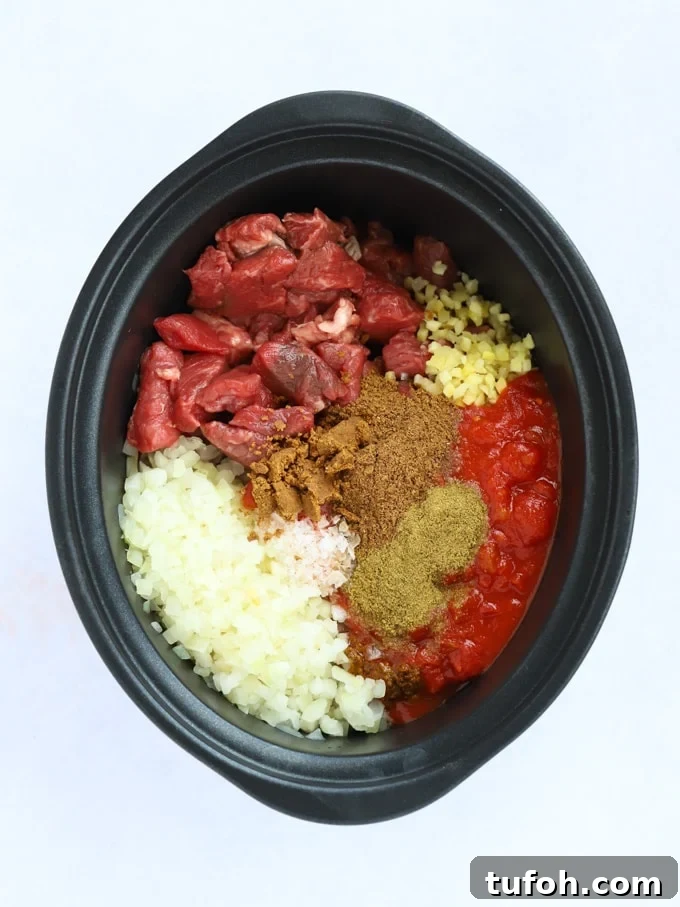Slow-Cooked Beef Curry: Tender Slow Cooker Recipe 4 Raw ingredients ready to be cooked with meat tomatoes and spices