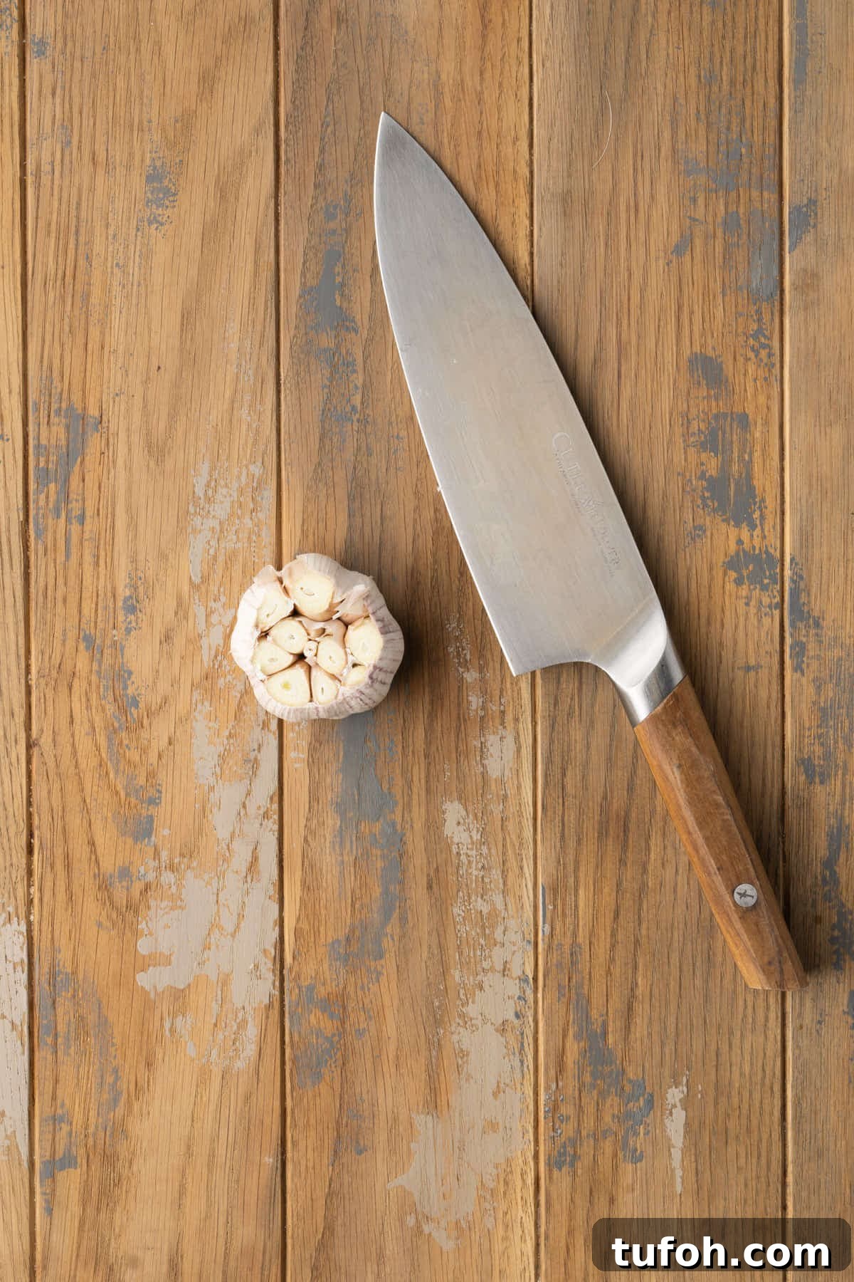A head of garlic with the top cut off to easily roast. 
