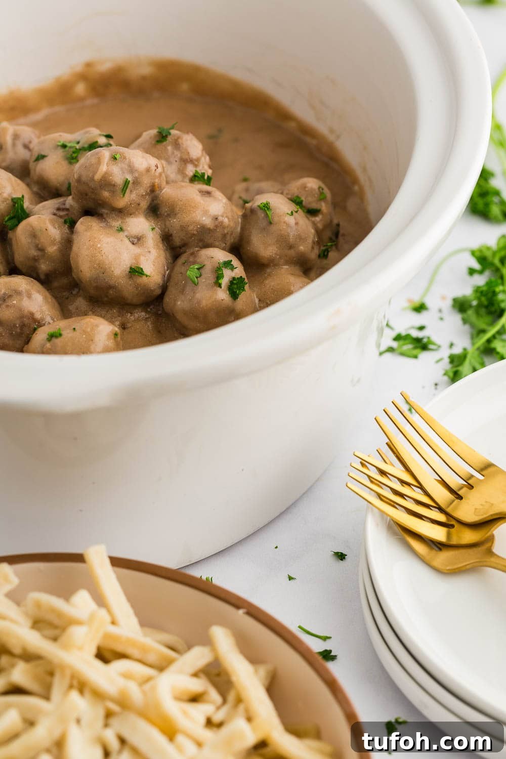 Swedish Meatballs in Slow Cooker with Creamy Sauce 6 Slow Cooker Swedish Meatballs in slow cooker next to pasta