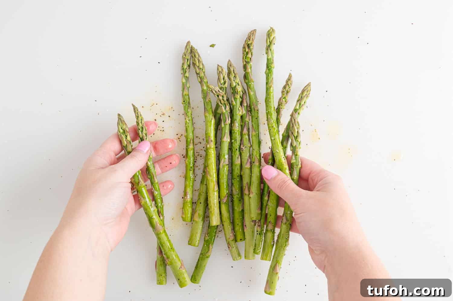Crispy Air Fryer Asparagus in Minutes 7 Asparagus being tossed with seasoning.