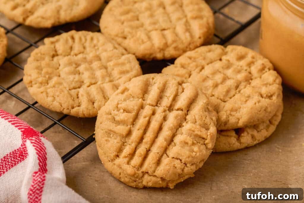 Chewy Peanut Butter Cookies Recipe with Crispy Edges 19 Close-up of golden brown peanut butter cookies on a wire rack showing detailed crisscross patterns.