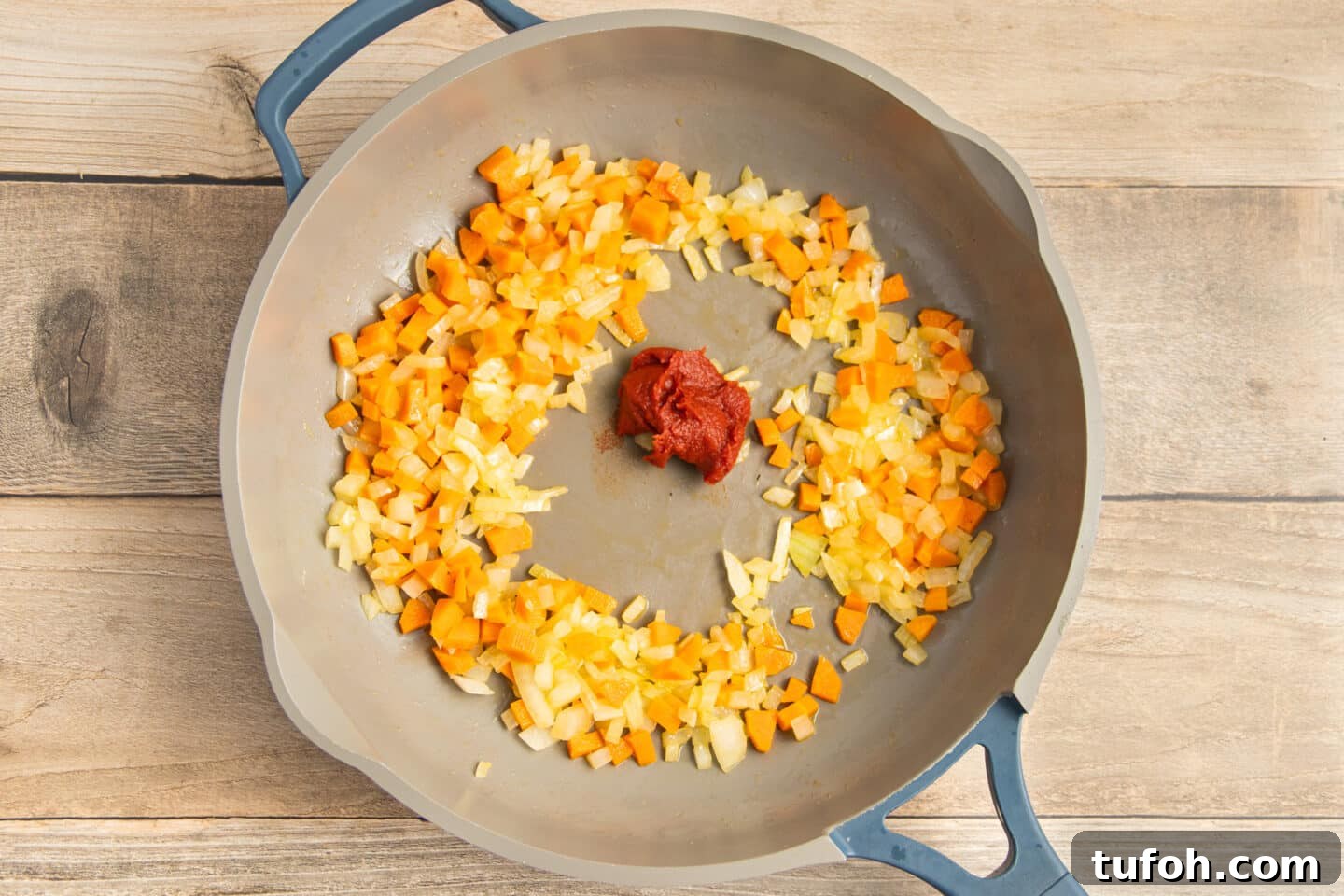 Creamy Tomato and Cottage Cheese Pasta Sauce Recipe 6 This is a picture of a skillet with onion and carrot cooking and tomato paste added.