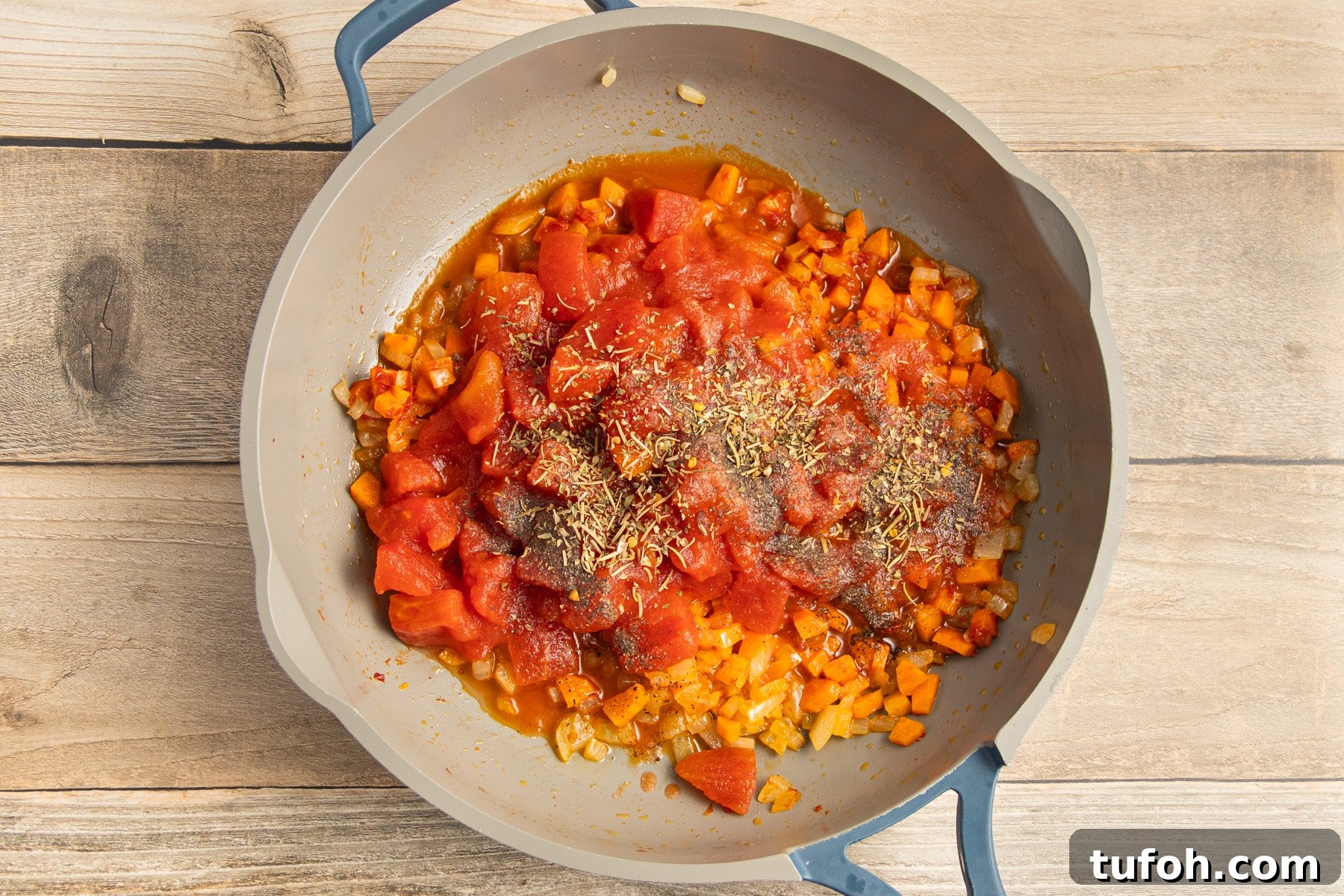 Creamy Tomato and Cottage Cheese Pasta Sauce Recipe 7 This is a picture of a skillet with onion and carrot cooking with tomato added.