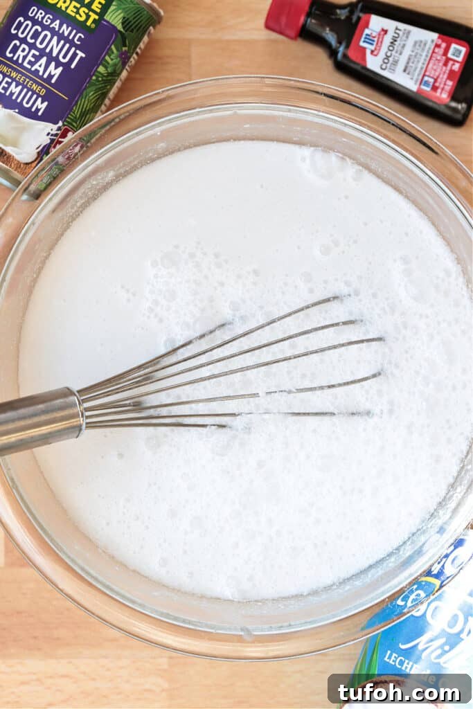 This homemade coconut sorbet is bursting with tropical flavor! Made with coconut milk and simple ingredients for a refreshing summer dessert. base for coconut sorbet in a bowl with whisk