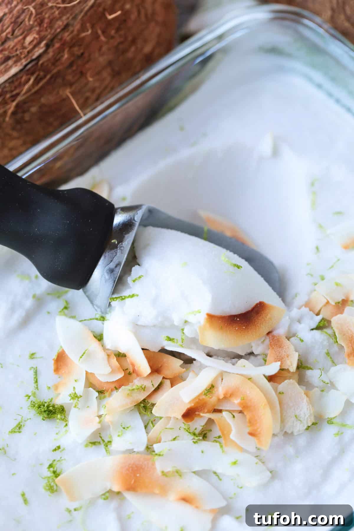 This homemade coconut sorbet is bursting with tropical flavor! Made with coconut milk and simple ingredients for a refreshing summer dessert. scooping sorbet out of dish