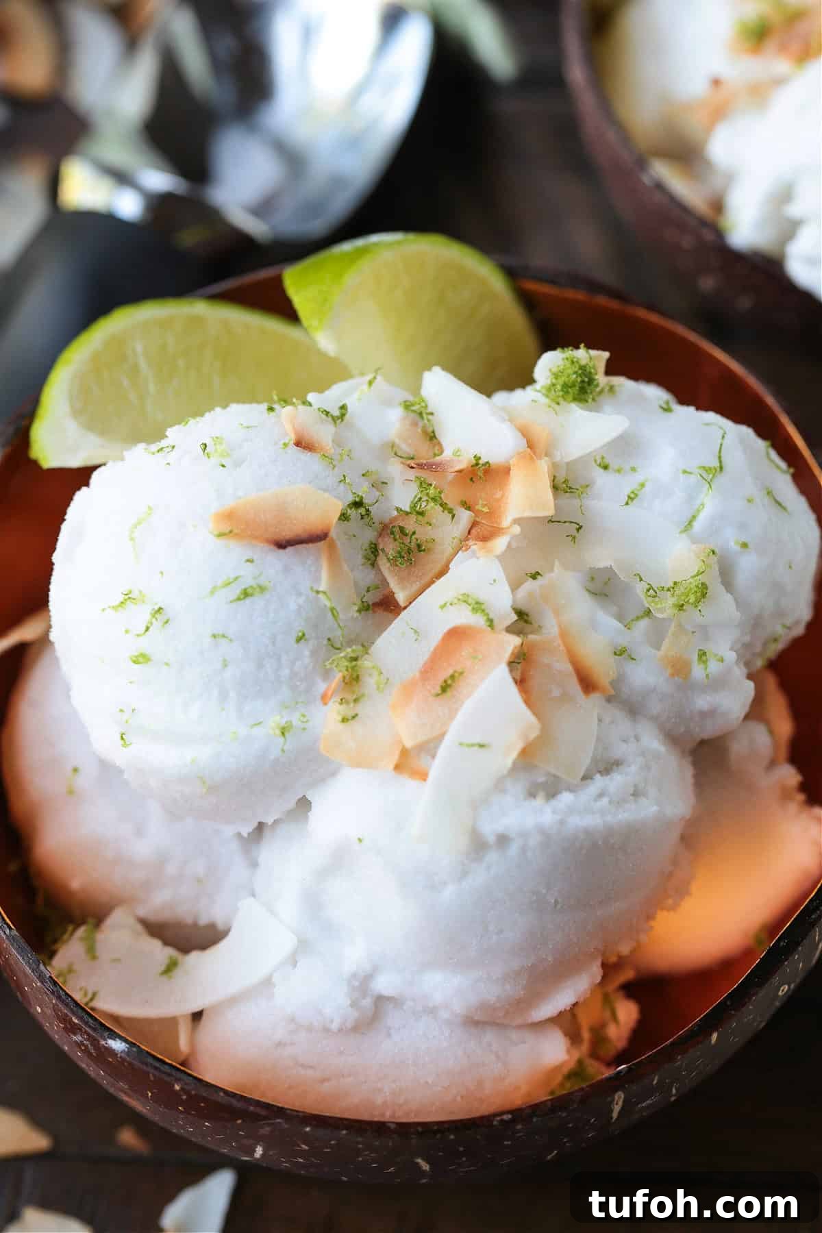 This homemade coconut sorbet is bursting with tropical flavor! Made with coconut milk and simple ingredients for a refreshing summer dessert. coconut sorbet in bowl with limes