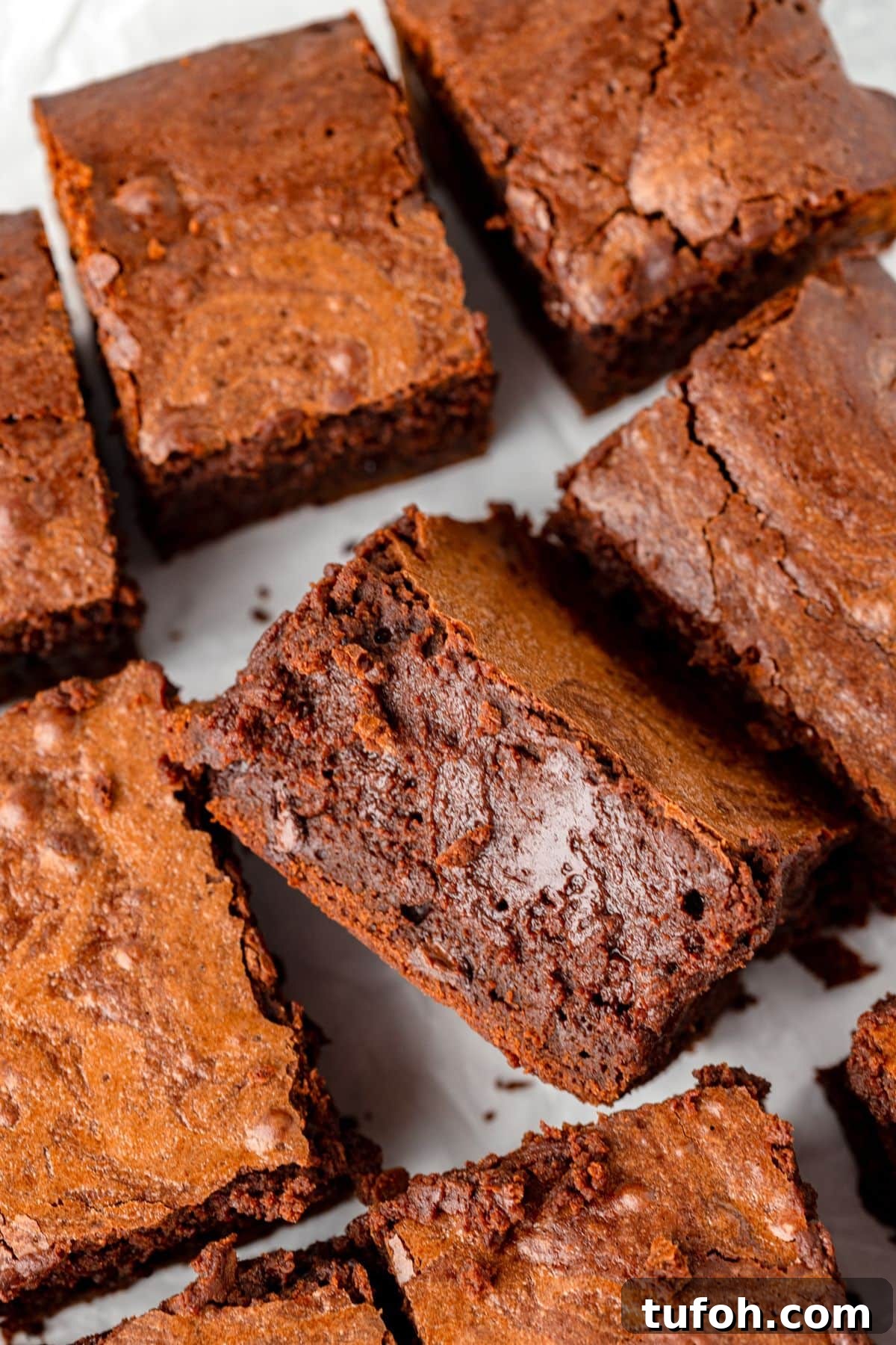 Close-up of several pieces of rich, fudgy chocolate brownies with a slightly cracked top.