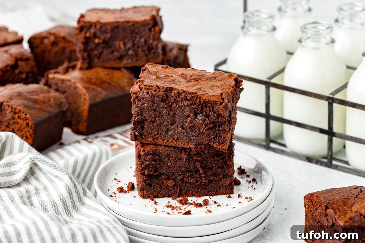 Two stacked sourdough brownies on a small white plate.