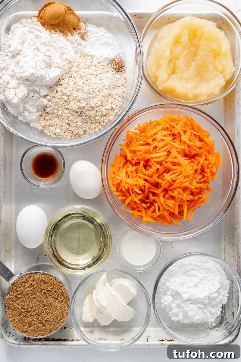 Moist Carrot Cake Muffins with Cream Cheese Swirl 3 Baking ingredients on a tray include grated carrots, flour, oats, applesauce, eggs, oil, cinnamon, vanilla, sugar, cream cheese, milk, brown sugar, and powdered sugar.