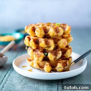 Spicy Green Chili Cheddar Waffles for Savory Brunch 12 Stack of green chili cheddar waffles with honey dripping down them.