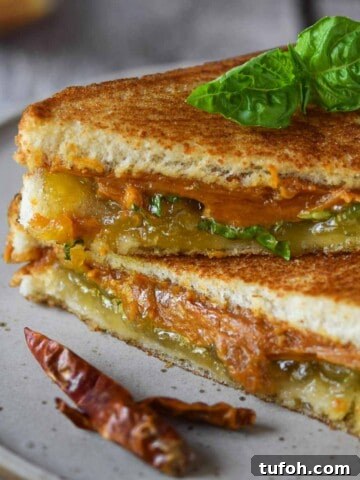 Thai peanut butter and jelly sandwich on a beige plate with a chili pepper next to it.
