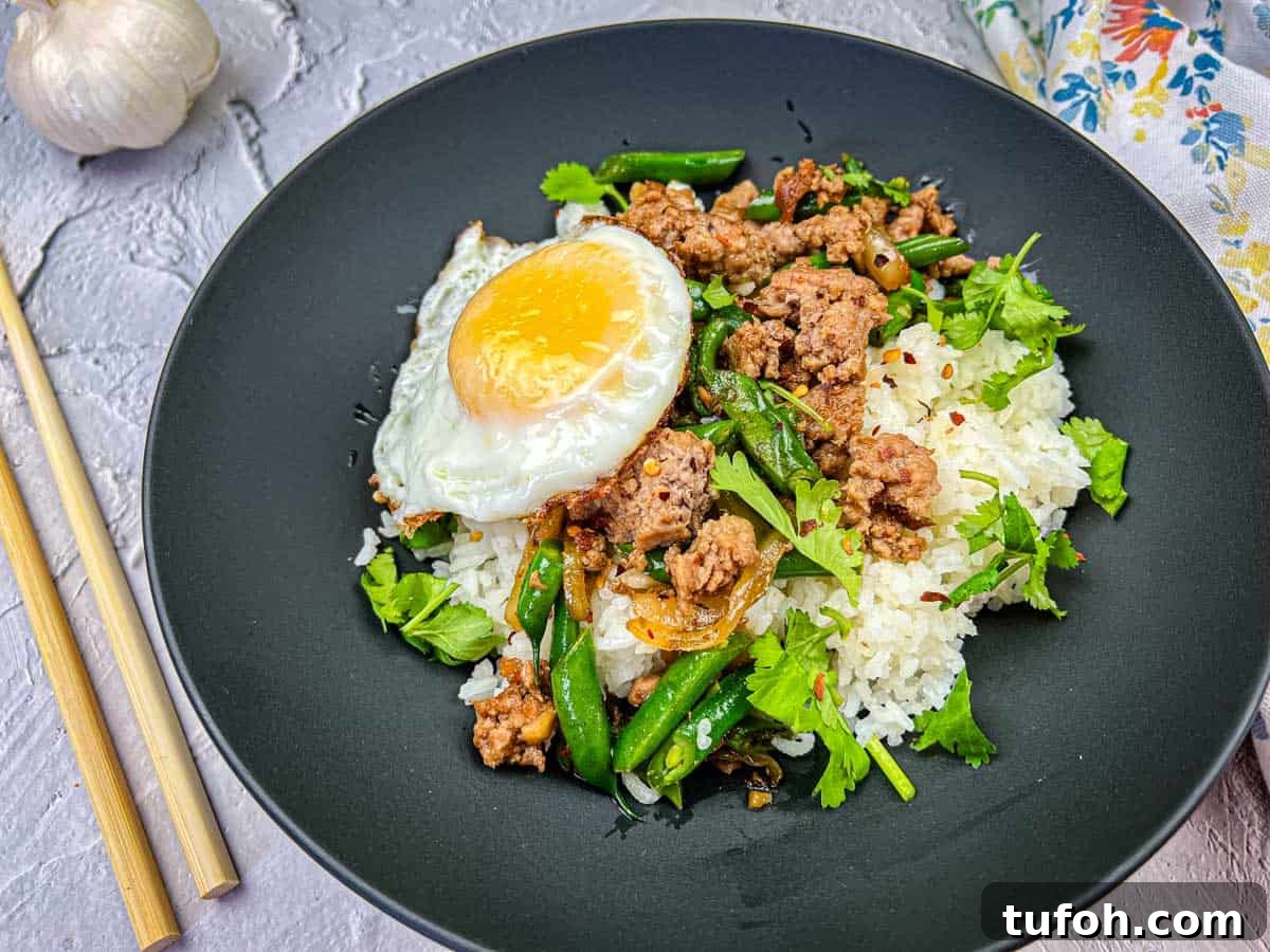 17 Crowd-Pleasing Backyard BBQ Recipes for Seconds-Worthy Meals 18 A plate of Thai pork & Green beans with rice, topped with a fried egg, served with chopsticks on the side.
