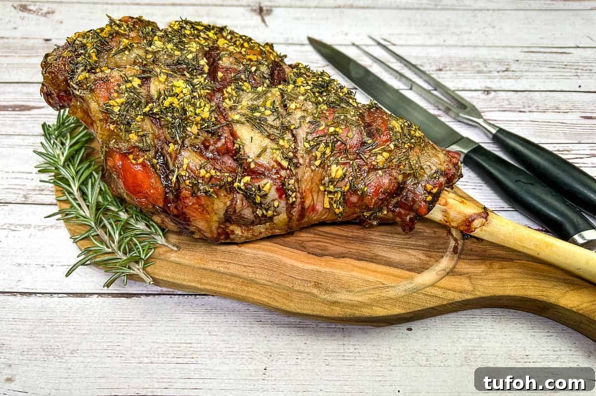17 Crowd-Pleasing Backyard BBQ Recipes for Seconds-Worthy Meals 3 Whole cooked leg of lamb on a board with a knife.