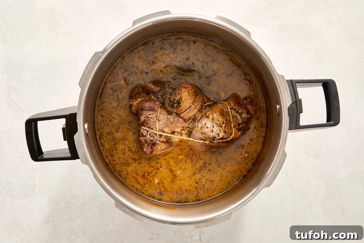 Cooked pork in broth inside a pot.