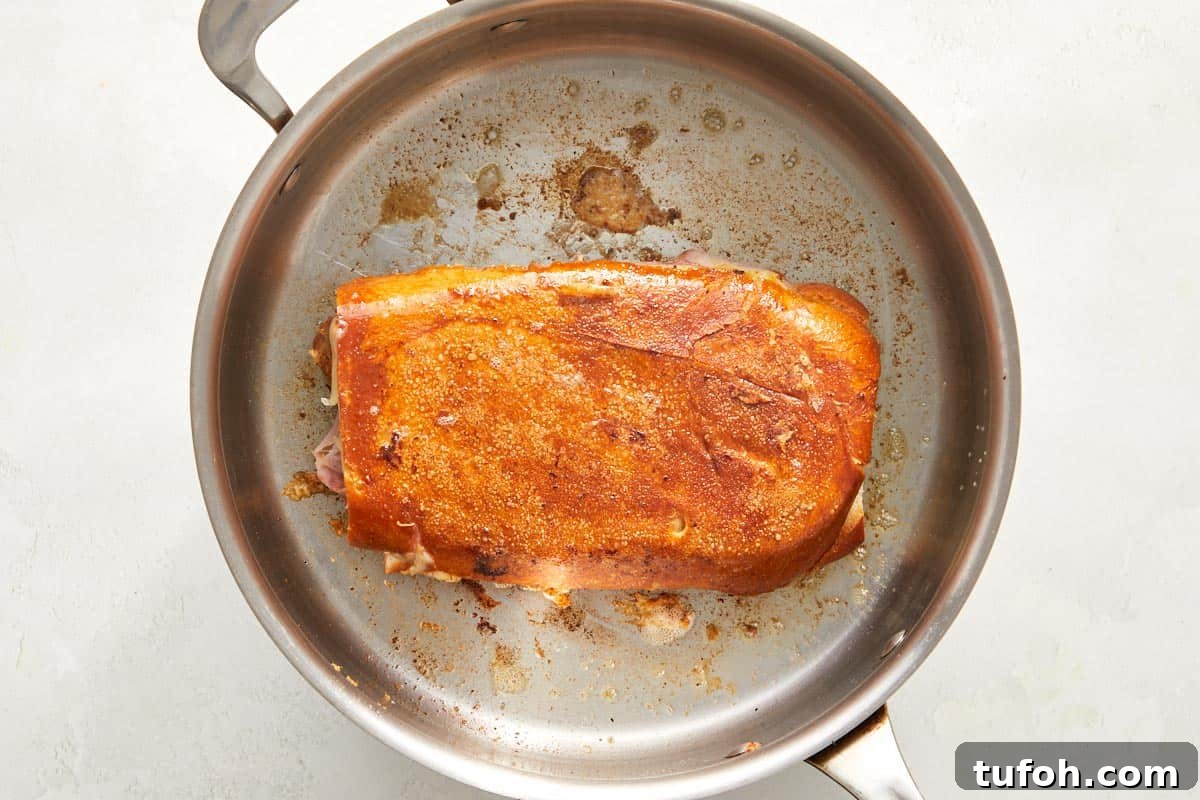 Cuban sandwich toasting in a skillet.
