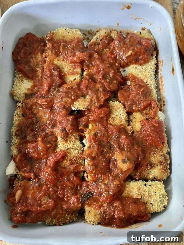 Zucchini Parmigiana with Ricotta: Layered Baked Zucchini Parmesan 12 Continuing the layering process with another layer of sauce.